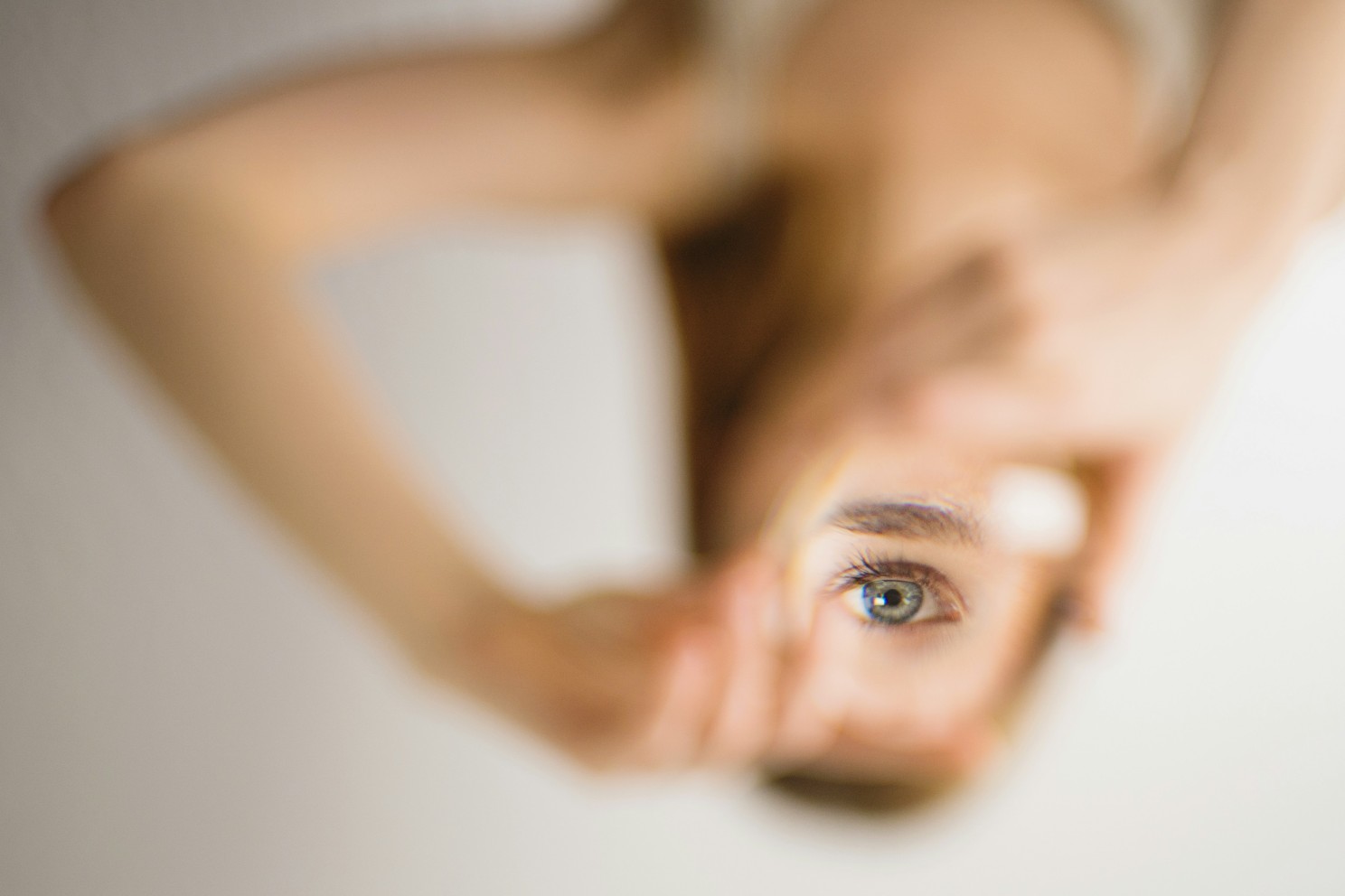 person holding up their hands to outline their own eye